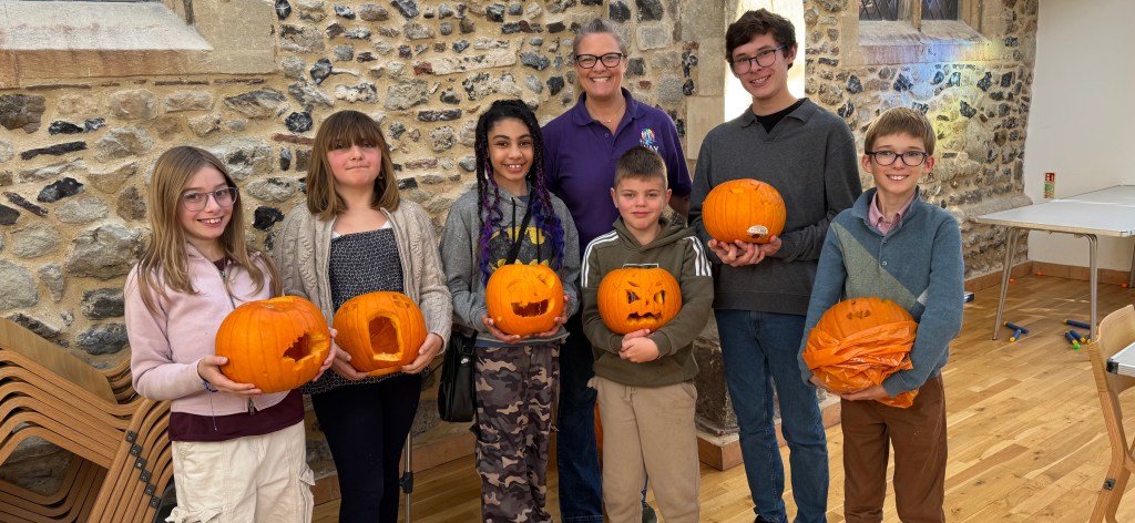 The Way members holding carved pumpkins